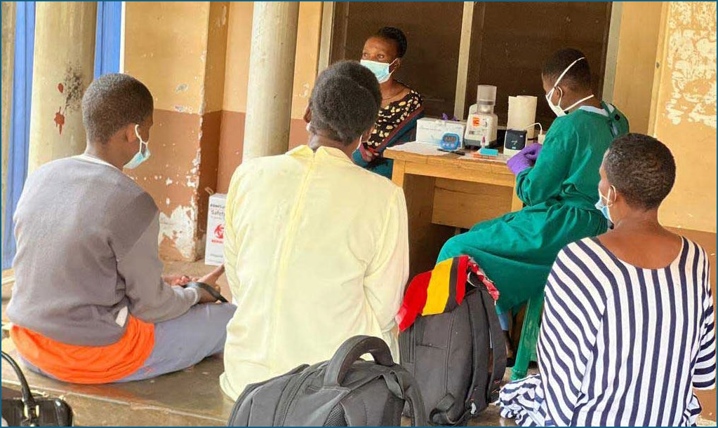 Patients in Uganda wait to take a TB test that delivers results in minutes, processed by tabletop devices rather than expensive laboratory facilities.
