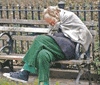 unhoused older man sitting on a bench