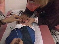 Health care worker moistens the tube in the child's mouth.