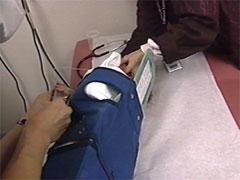 Health care worker gently aspirating with syringe as the child is turned on their side