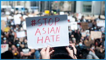 hands holding sign that say stop asian hate
