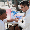 Medical student Miguel Garcia explains the TB screening process to Sharon Beal, a resident on Gladys Avenue.