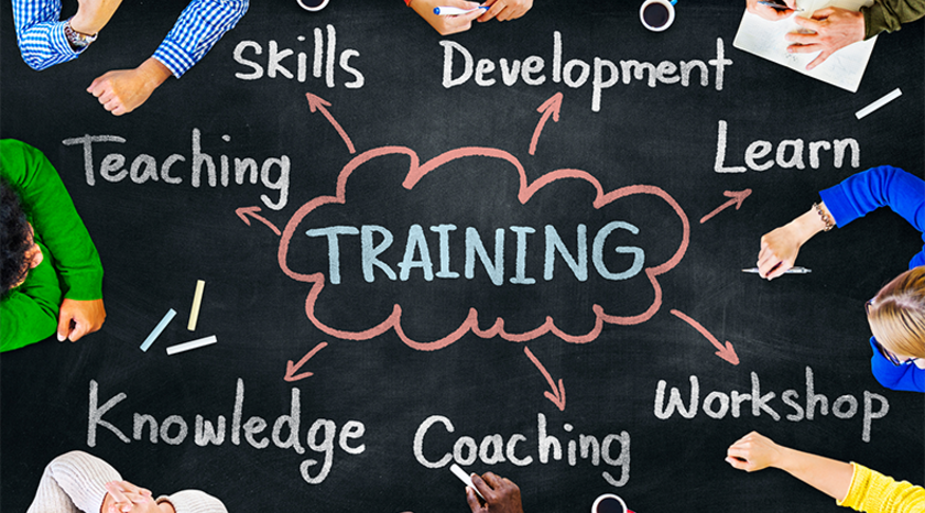 arms of people in different colored shirts pointing the word training
